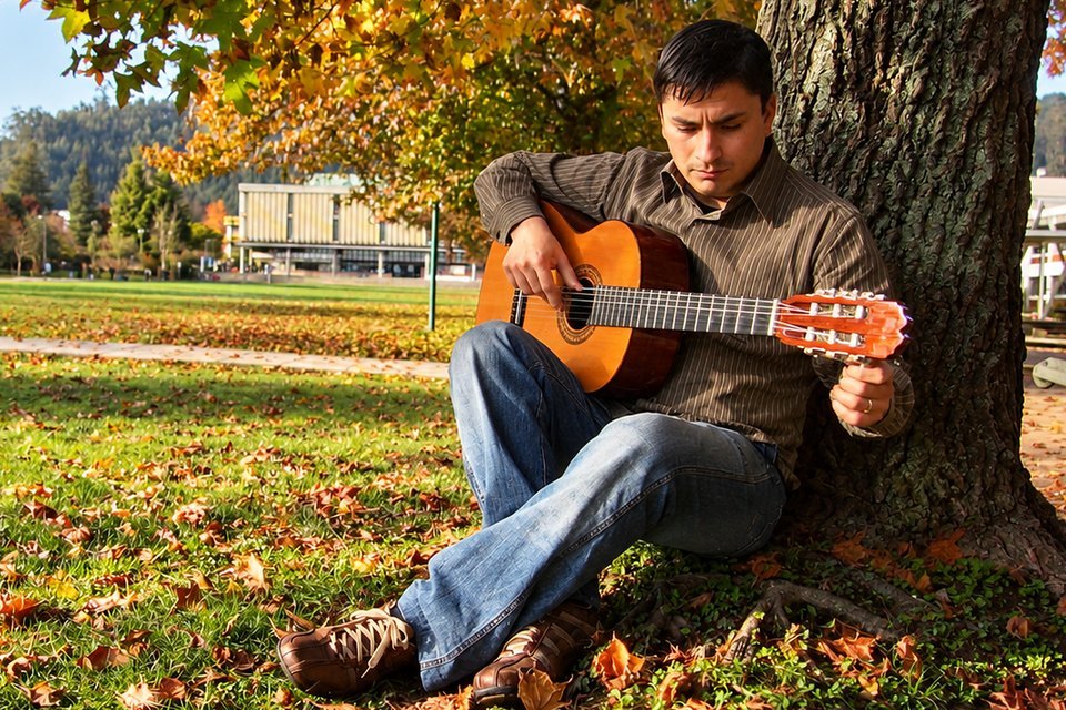 Alejandro Luna con una guitarra clásica, sentado bajo un árbol en otoño